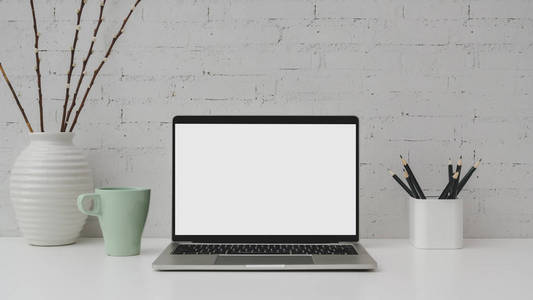 Close up view of  workspace with blank screen laptop, pencils, c