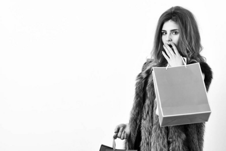 时尚人士在商店里买时髦的衣服.女孩化妆脸长发型穿皮草背心白色背景.