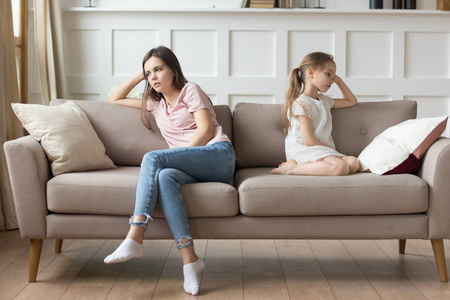 倔强吵架后不开心的妈妈和倔强的学龄前女儿照片