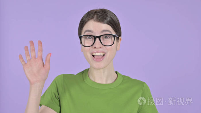 在紫色背景下年轻女子对着镜头挥手致意