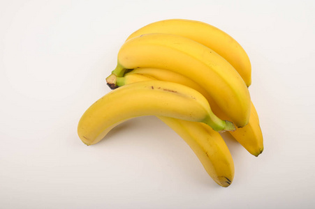 白色背景上的一串成熟的黄色香蕉。闭合。