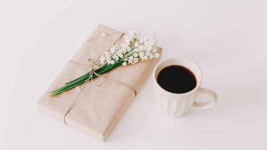 白色背景上的咖啡，礼物和鲜花的浪漫构图。节日生日国际妇女节的概念