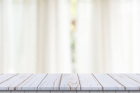 Empty wood table top on blur white window background. For produc