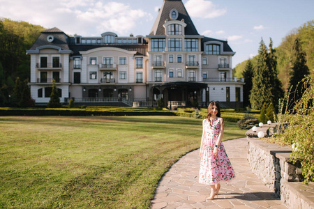 Elegant lady walking by the hotel. Spring day