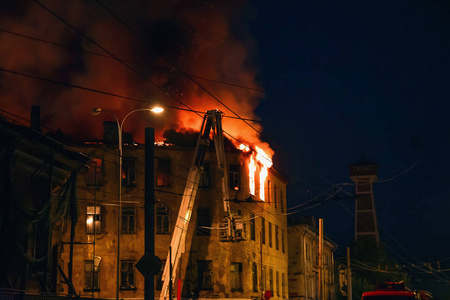 夜间楼顶起火,房屋冒烟燃烧,引发火灾照片