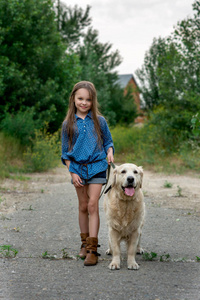 Little girl playing with her big dog outdoors in rural areas in 