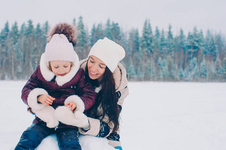 快乐的妈妈和孩子一家人享受冬天的雪天