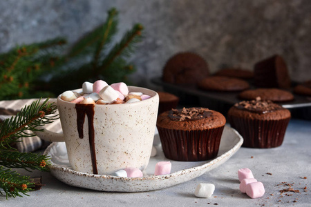 Christmas drink  hot chocolate with marshmallows and a cupcake 