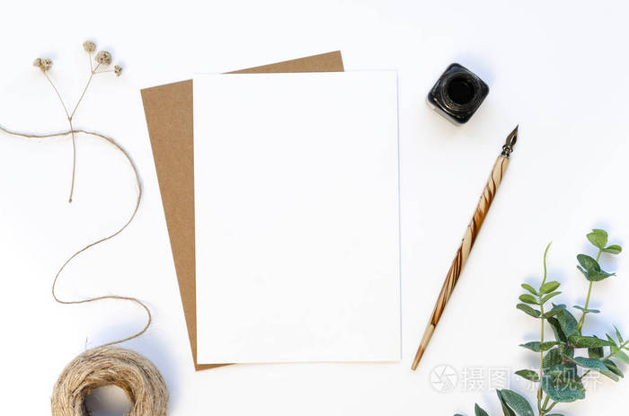 带墨水瓶和空白纸的钢笔模型字母手工纸麻线和桉树树枝在白色桌面上的
