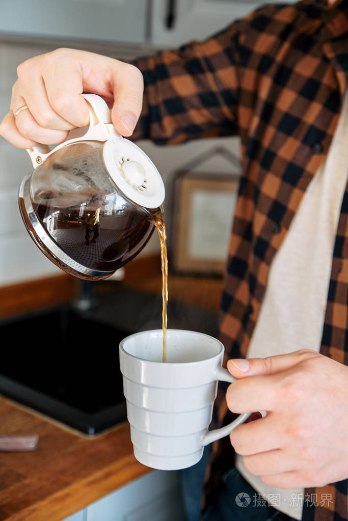 白种人往杯子里倒咖啡