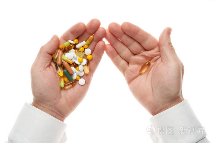 从白色背景上分离的一把药丸药片维生素药物胶囊中取出一粒药丸白衬衫