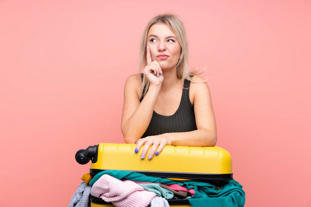 一个旅行的女人拿着一个装满衣服的手提箱
