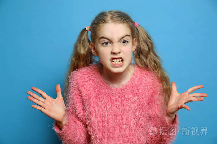 孩子的情绪小女孩气得孤立无援漂亮的小女孩在蓝色背景下生气愤怒的