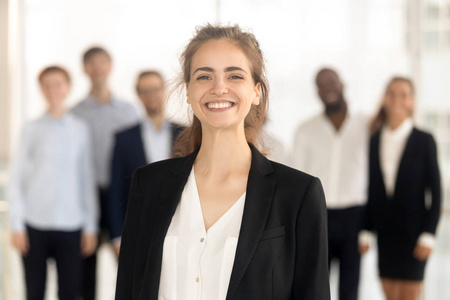 笑脸盈盈的女员工的画像,背景是同事照片