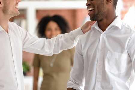 微笑男士拍肩问候同事特写镜头照片