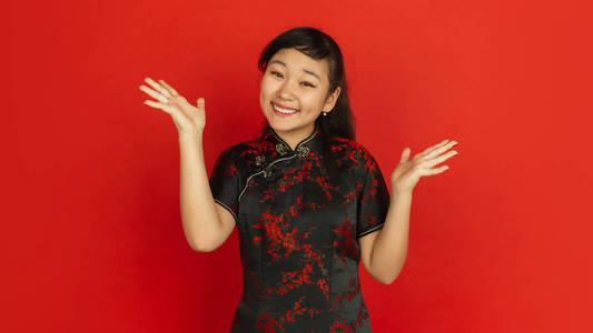 春节快乐。红色背景上孤立的亚洲少女肖像