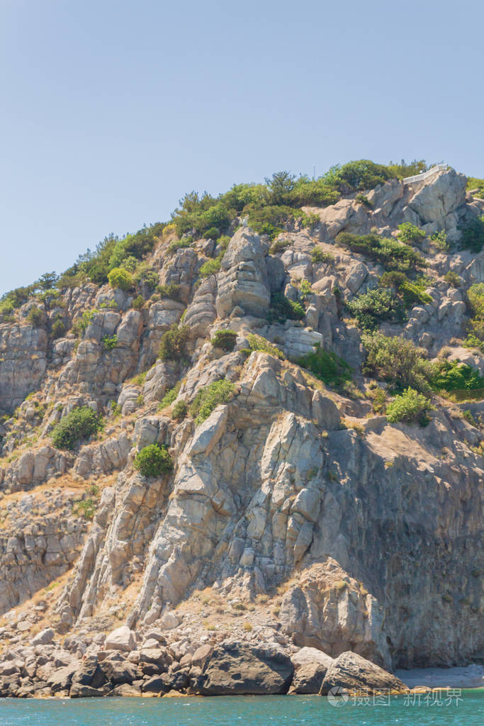 夏日阳光明媚的海滩上的山石