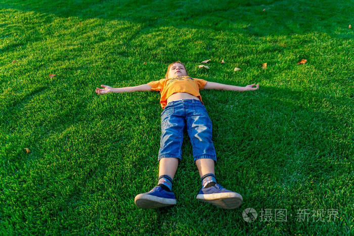 男孩躺在绿草上仰望天空