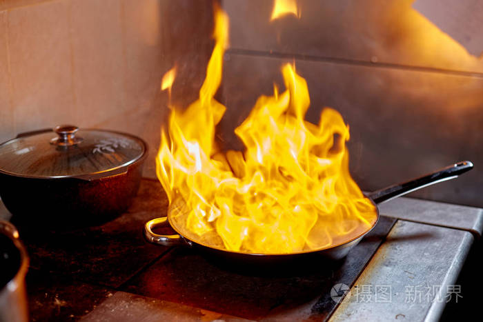 弗拉姆贝煎锅里着火了商业厨房烹饪专业厨师在室外厨房的炉架上一个