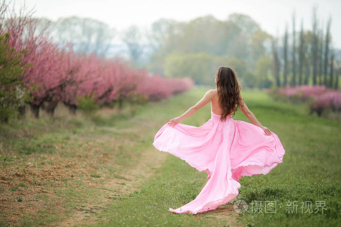 自然公园背景下穿着粉色连衣裙的全身美女
