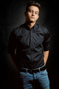 Fashion portrait of young man in shirt on black background 