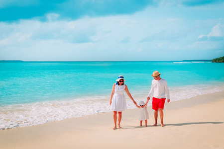 妈妈，爸爸和小女儿在热带海滩散步