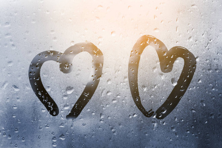在雨天的玻璃上画上心形,用经典的蓝色调成色调照片