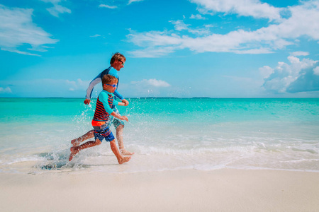 父子俩玩水，幸福一家人在沙滩上奔跑