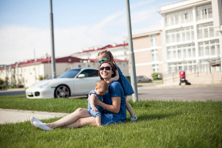 带着女儿的年轻母亲坐在草地上