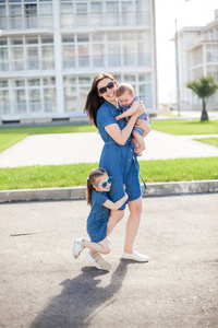 young mother and daughters outdoor. Happy family. 