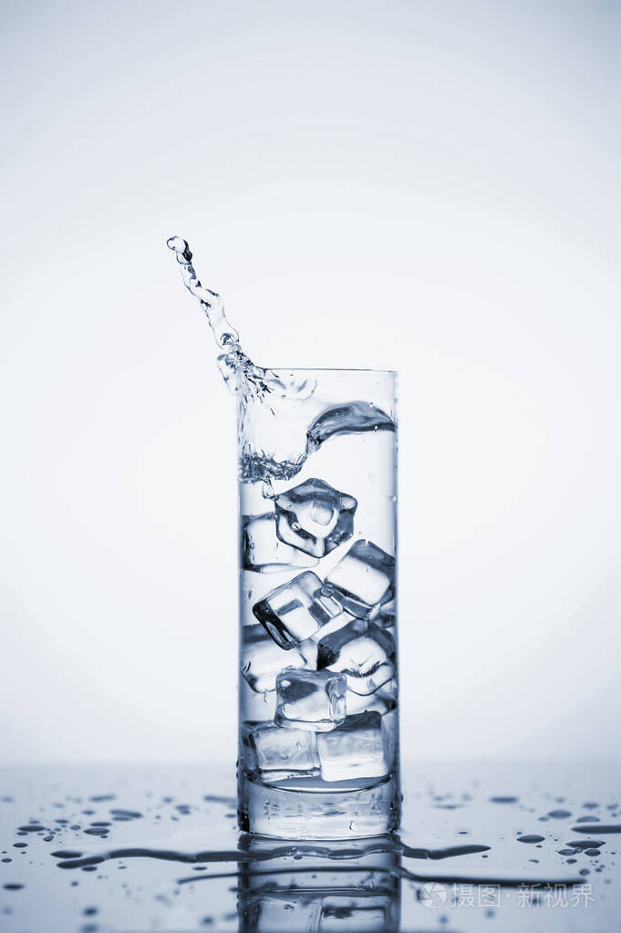 清澈的矿泉水在一个有冰的玻璃杯里飞溅