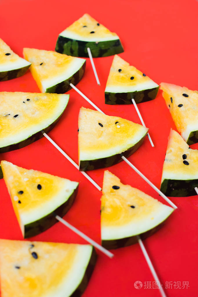 在白色背景上切下三角形的熟黄色西瓜片