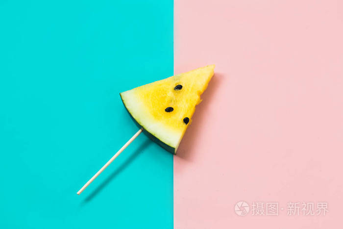 在粉蓝色的背景上切下三角形的熟黄色西瓜片