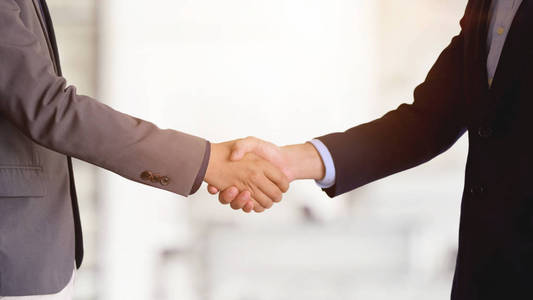 Two of business people shaking hands after finishing up a meetin