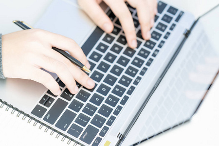 在家办公的妇女使用笔记本电脑搜索网络，浏览