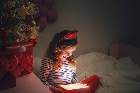 快乐的小女孩拿着一个神奇的圣诞盒子和一个g
