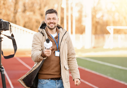 体育记者体育馆里拿着麦克风的男记者照片