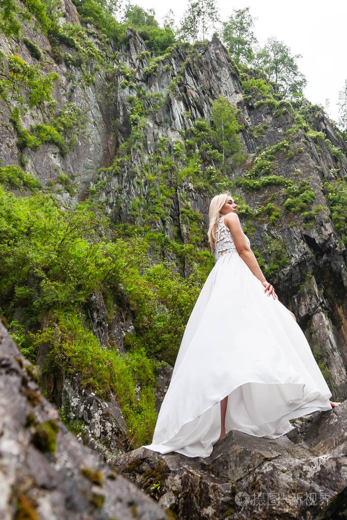 一个年轻的金发女孩背着背站在白色的闺房里