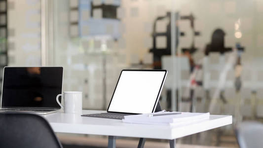 Cropped shot of workplace with blank screen tablet, laptop, offi