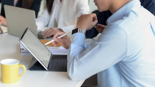 Cropped shot of businessman writing on blank screen tablet while