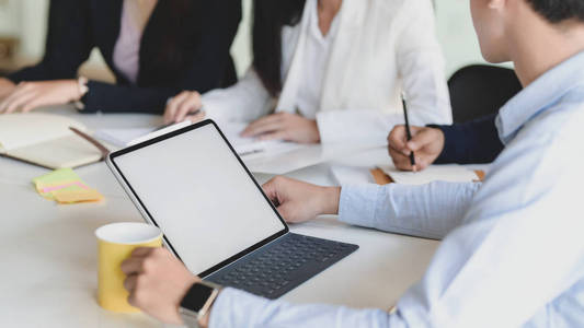 Cropped shot of businessman with blank screen tablet while worki