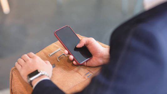 Cropped shot of young professional businessman using smartphone 