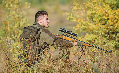 猎人拿着步枪.男人穿迷彩服自然背景.狩猎许可证照片