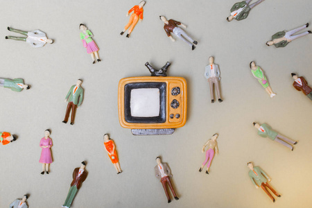 Figurine people around retro syled tiny television 
