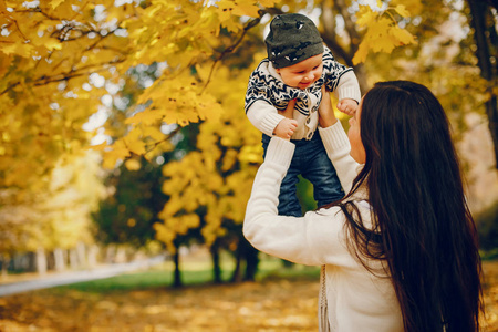 一家人带着小儿子在秋天的公园里