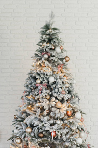 Beautiful glowing white snowcovered Christmas tree in the home 