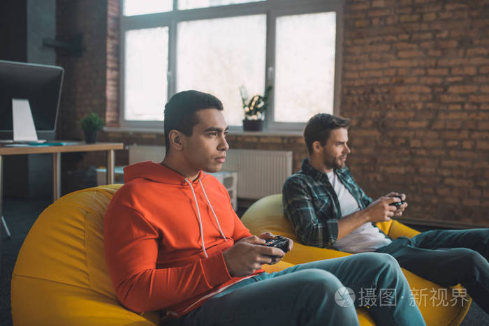 严肃的年轻人拿着游戏机