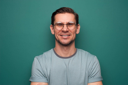 看你表演表情包一个戴眼镜的积极的年轻人的画像照片