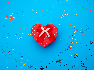 closed red heartshaped cardboard box on a blue background with 