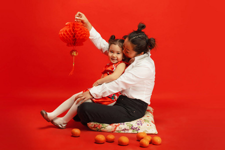 春节快乐。亚裔母女肖像隔离在红色背景上